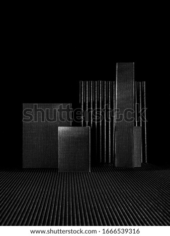 Still life of triangle fold black paper on black background. Minimalistic black.
