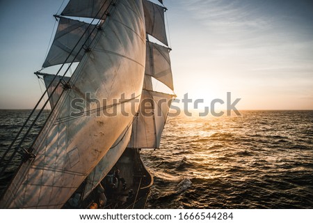 Old tall ship sails backlit Royalty-Free Stock Photo #1666544284