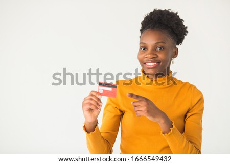 beautiful young african woman on white background with credit card in hand
