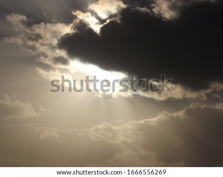 bright sun behind dark cloud