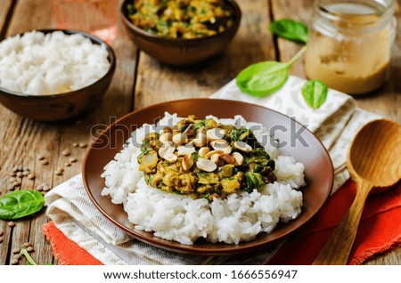 lentils, peanut butter spinach curry with rice on a wood background. toning. selective Focus