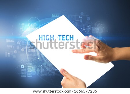 Hand holdig futuristic tablet with HIGH-TECH inscription, new technology concept