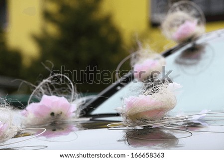 Wedding car decorated with pink flowers and ribbons