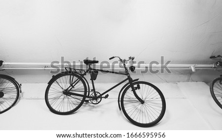 Suspended black bikes on white background in a hipster style. Vintage bicycles as a decoration in the room. Minimalist Black decoration.