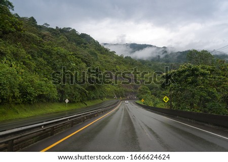Road wet by rain among lush vegetation. Colombia Royalty-Free Stock Photo #1666624624