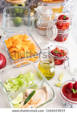 Batch cooking scene full of container glasses with delicious meal inside them on a white wooden table. Royalty-Free Stock Photo #1666654819