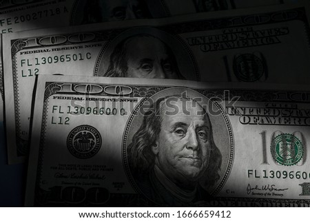 Photography is very high-resolution images of U.S. dollars $ 100 neatly stacked in the background the dark light. Stufio shoot.