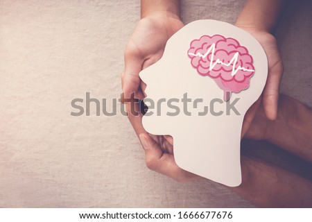Adult and child hands holding encephalography brain paper cutout,autism, Stroke, Epilepsy and alzheimer awareness, seizure disorder, stroke, ADHD, world mental health day concept Royalty-Free Stock Photo #1666677676