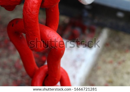 Link element of a chain of red color, massive metal, background