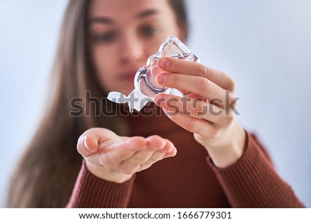 Woman applying an antibacterial antiseptic gel for hands disinfection from bacteria. Health protection during flu virus outbreak, epidemic and infectious diseases Royalty-Free Stock Photo #1666779301