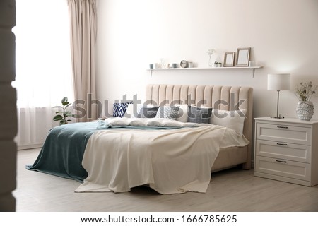 Comfortable bed with pillows in room. Stylish interior design Royalty-Free Stock Photo #1666785625