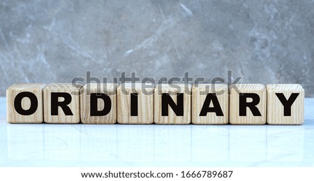 concept of the word ordinary on cubes on a marble gray background