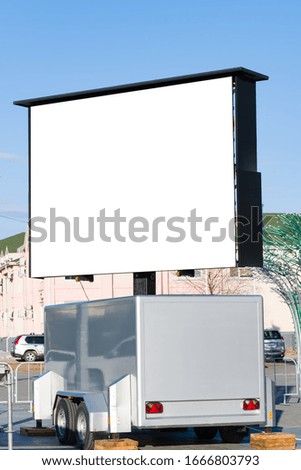 Bulletin Board, a Billboard with an empty white space for text on a city street .