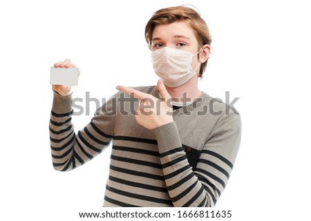 Isolate photo of Caucasian guy in medical mask with a business card in his hands