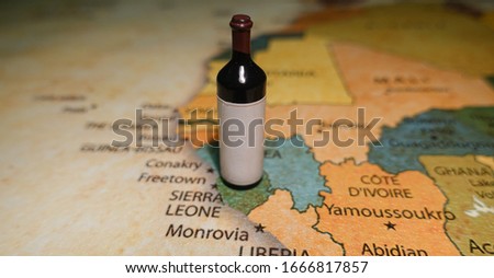 A bottle of red wine on a map of Sierra Leone.