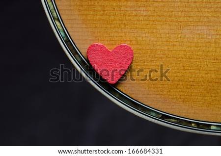 Red heart on edge of acoustic guitar