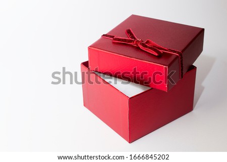 Open, red, decorative gift box on a white background from close up