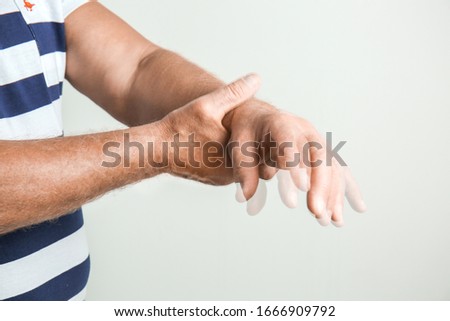 Senior man suffering from Parkinson syndrome on grey background Royalty-Free Stock Photo #1666909792