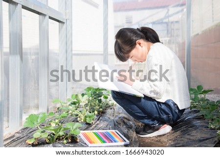 Elementary school girl sketching in the garden at home