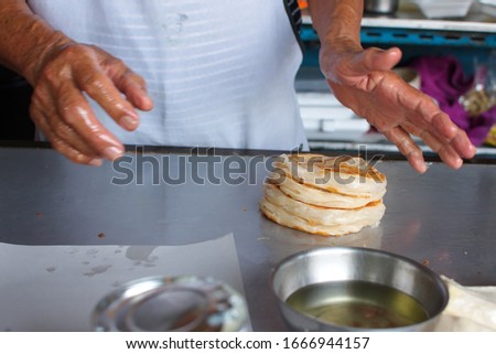 Hand's chef making roti, crop picture, closeup at man's hands and heap of naan bread, popular India street food, homemade, Handmade cooking concept