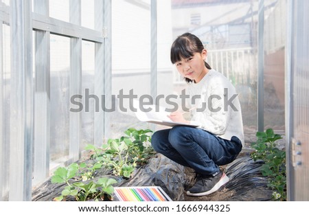 Elementary school girl sketching in the garden at home