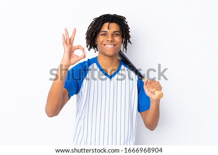 Young African American man playing baseball over isolated white background showing ok sign with fingers