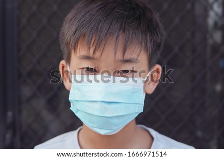 Asian preteen boy wearing medical face mask, self-quarantine,  social distancing, coronavirus, covid-19  delta virus pandemic, pm 2.5 air pollution and health concept