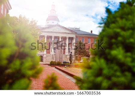 Spring time view of Maryland State House capitol building through bushes and trees, Annapolis MA, USA
