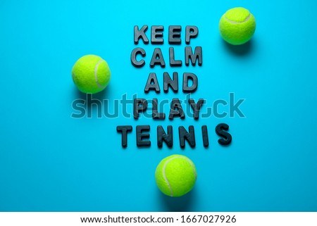 top view flat lay tennis balls and inscription keep calm and play tennis  on a bright blue background 