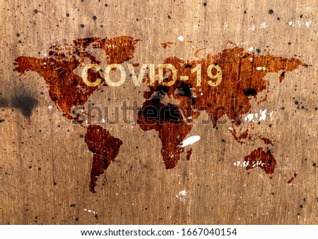 COVID-19 lettering on world map on wooden wall background. COVID-19 coronavirus concept background Royalty-Free Stock Photo #1667040154