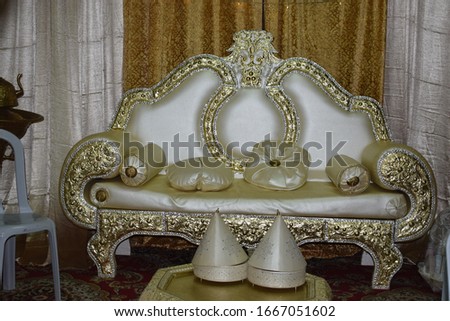 white and gilded sofa with pillows for an oriental holiday, a table with refreshments, elegant traditional interior