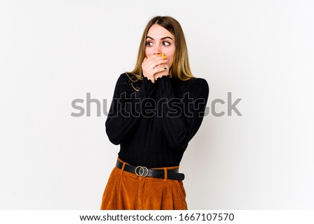 Young caucasian woman isolated on white background thoughtful looking to a copy space covering mouth with hand.