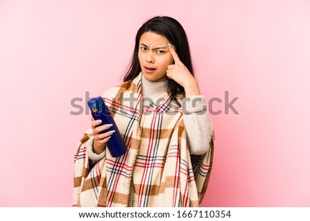 Young chinese woman doing a camping isolated on pink background pointing with finger at you as if inviting come closer.