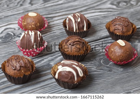 Chocolate Potato Cake. Some decorated with sprinkles, others with chocolate. Against the background of brushed boards.