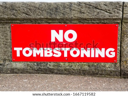 Red sign warning that there is no tomb stoning (jumping into the harbour) allowed at Bridlington, East Yorkshire, UK. 