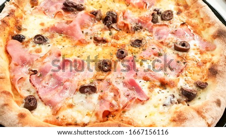   Close up of Capricciosa italian  style pizzawith fresh mushrooms and cherry  tomatoes. Cherry tomato, yellow cheese, basil, ham, garlic, mushrooms,  tomato sauce 