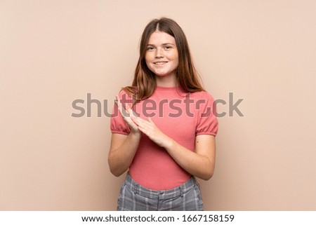 Ukrainian teenager girl over isolated background applauding