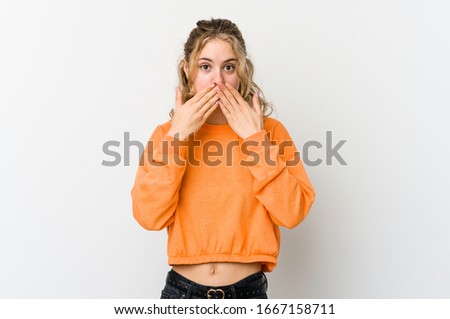 Young caucasian woman on white backrgound shocked covering mouth with hands.
