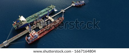 Aerial drone ultra wide photo of industrial fuel and gas tanker ship docked in Mediterranean port with deep blue sea