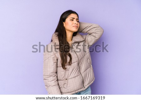 Young indian woman isolated on purple background tired and very sleepy keeping hand on head.