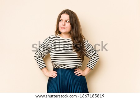 Young curvy woman confused, feels doubtful and unsure.