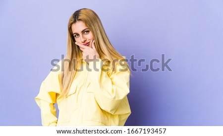 Young blonde woman isolated on purple background contemplating, planning a strategy, thinking about the way of a business.
