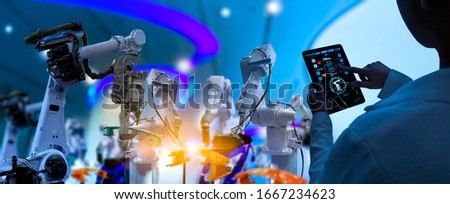 Factory Female Industrial Engineer working with automation robot arms machine in intelligent factory industrial on real time monitoring system software.Digital future manufacture. Royalty-Free Stock Photo #1667234623