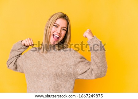 Young blonde caucasian woman isolated raising fist after a victory, winner concept.
