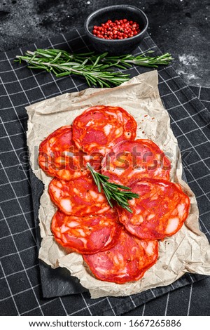 Sliced chorizo salami. Spanish traditional chorizo sausage. Black background. Top view