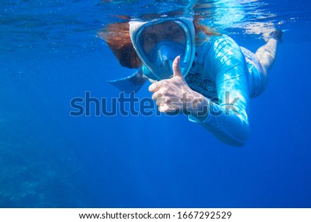 Woman in snorkeling mask underwater photo. Female snorkel show thumb undersea. Snorkeling in tropical sea. Summer vacation outdoor activity. Tropical island adventure. Diving banner template