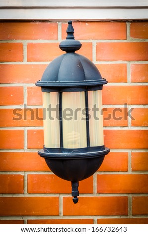 Old lamp lantern on the stone wall , process in vintage style picture