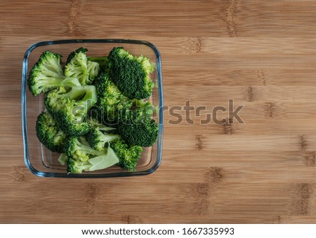 Broccoli in pan on wooden table, high resolution photo .