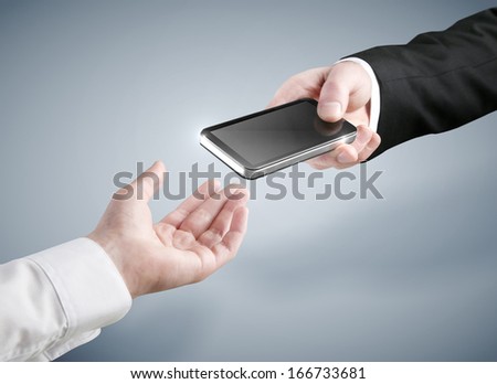 Hand putting a phone into other hand isolated on blue background