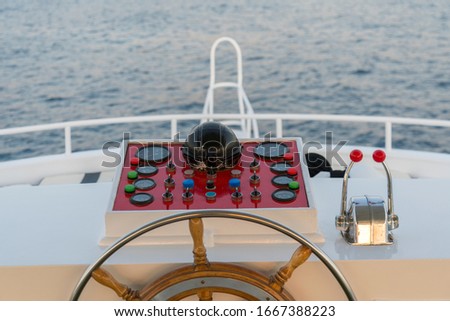 Yacht steering wheel on blue sky background. The yacht's steering wheel sails on the sea